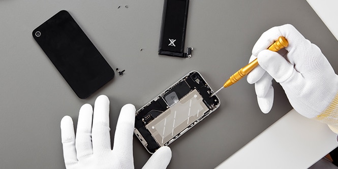 Image of two hands investigating interior of a cell phone for electronics bonding.
