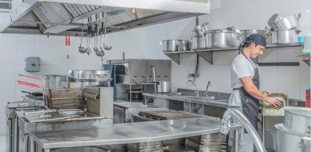 Employee washing dishes in a commercial kitchen
