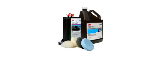 Two black jugs and four polishing pads in different colors.
