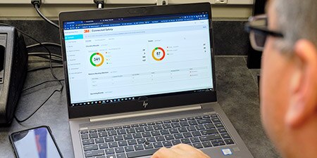 Man looking at laptop on work bench
