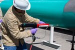 Man spraying protective coating on pipe