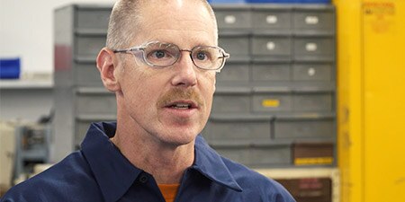 Man being interviewed in warehouse
