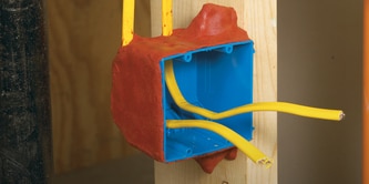 An electrical box with wires protruding, surrounded by red fire protection putty.]

