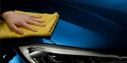 hand applying ceramic coating to the exterior of a car
