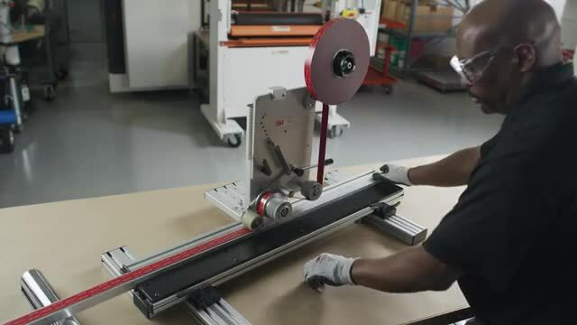 Image of someone pushing a post through the 3M™ Straight Line Laminator
