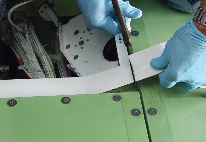 Person in blue gloves cutting and applying 3M™ Corrosion Prevention Sealing Tape