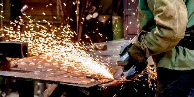 Operator grinding metal with grinding wheel
