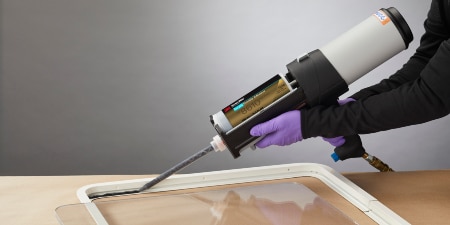 Applying 3M™ Scotch-Weld™ Flexible Acrylic Adhesive DP8610NS to a window frame to bond polycarbonate

