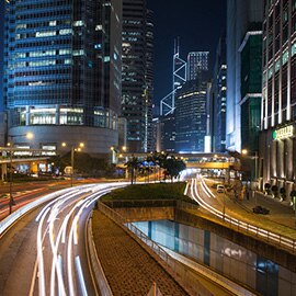 City scape at night, illuminated skyscrapers, city roads.