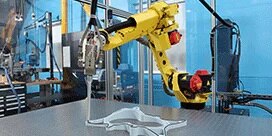 A large machine is shown applying an adhesive

