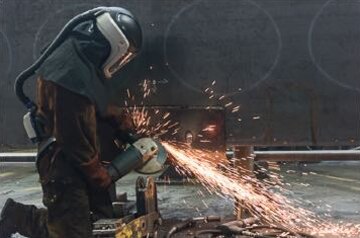 Grinder using the 3M™ Adflo™ Powered Air Purifying Respirator (PAPR) System 
