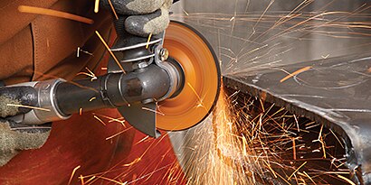 Using a weld grinder to bevel, sparks fly.
