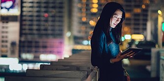 Person using a tablet with a bright display screen.
