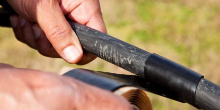 worker wrapping damaged cable in 3M Electrical Tape
