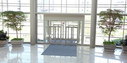 Building lobby with many windows and a shiny floor.
