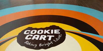 A floor graphic displays a colorful, circular branding design for 
