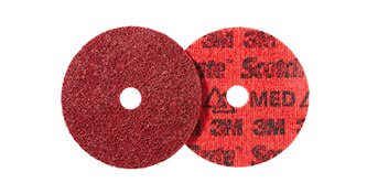 The image shows two 3M red abrasive discs with a hole in the center.
