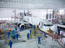 Industrial Manufacturing team work on military aircraft in hanger