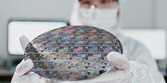 A lab worker examining semiconductor technology.

