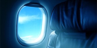 Interior of airplane showing seat and window.
