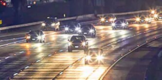 Vehicles driving at night on a highway.

