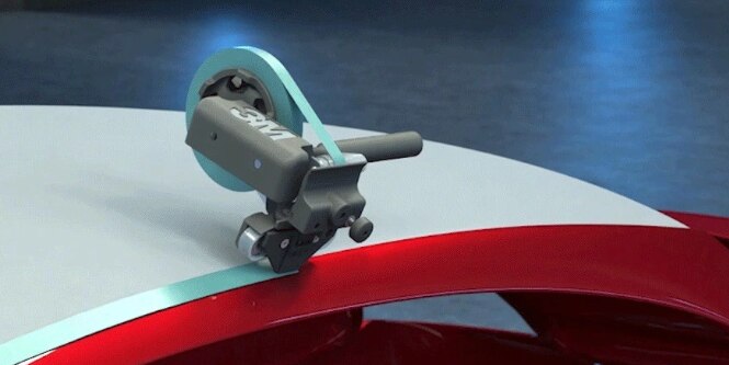 3M™ Adjustable Paint Masking Applicator applies masking tape along a vehicle roofline.
