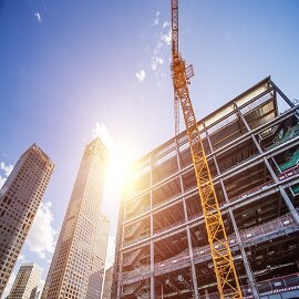 A crane is positioned next to a building under construction