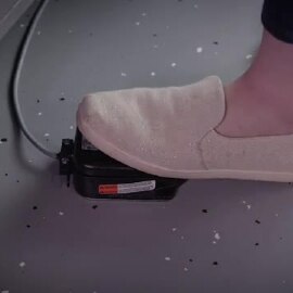 Video still of a worker depressing the foot control to dispense adhesive