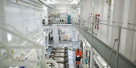 A person performs an inspection on a ship
