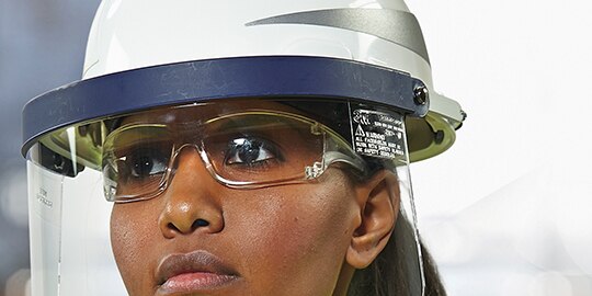 woman wearing hardhat with faceshield
