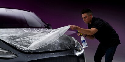 installer placing PPF on a car's hood.
