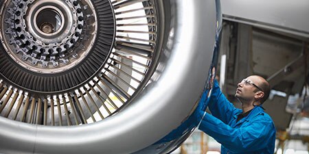 A man works on an aircraft engine
