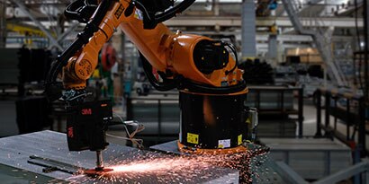 Robot grinding a weld with a fiber disc

