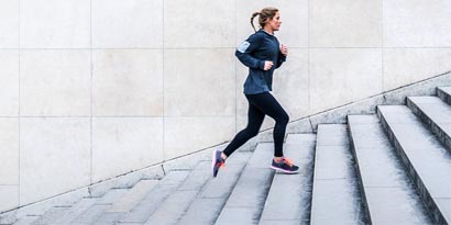 Woman jogging up a flight of stairs

