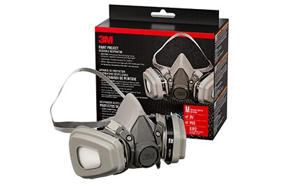 Gray respirator mask with dual filters, placed in front of its 3M packaging box.