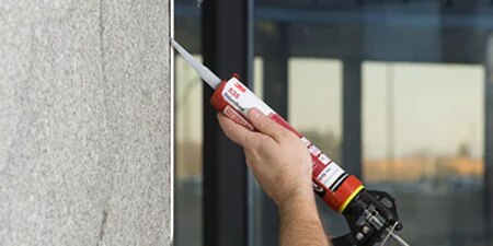 Worker sealing a joint between different materials
