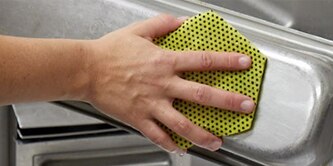 Scotch-Brite™ HEX Series sponges cleaning a stainless steel pan
