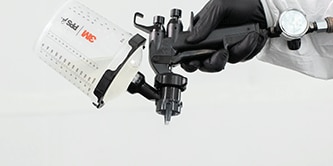 A grey seam sealer bead being applied to the body of a car.
