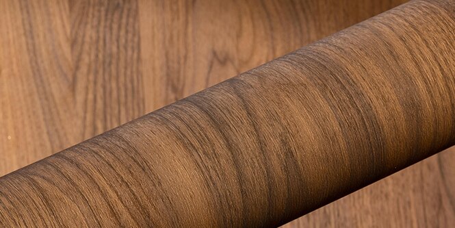 Roll of wood grain DINOC architectural finish on wood grain background
