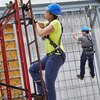 Worker climbing ladder in fall protection training facility