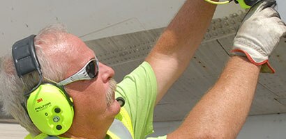 Man wearing PPE working on a plane
