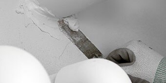 Worker sealing a joint around a pipe
