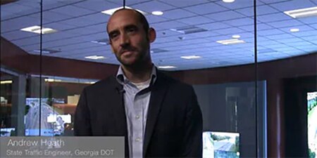 A photo of a man speaking about wet retroreflective pavement markings.
