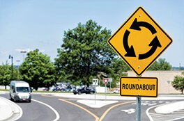 A tidy roundabout on a sunny day with a yield sign at the entrance.