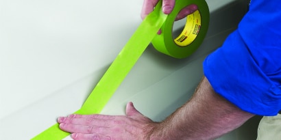 worker applying masking tape
