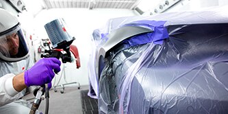 Technician painting a car
