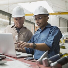 image of two men looking at a laptop