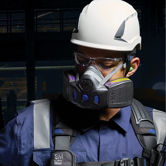 Worker checking fall protection harness