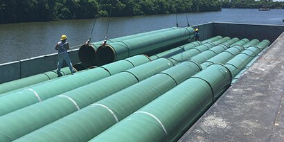 Loading coated pipes onto barge

