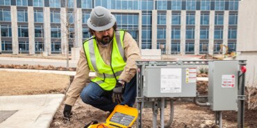 Field technician locating and marking underground wiring.